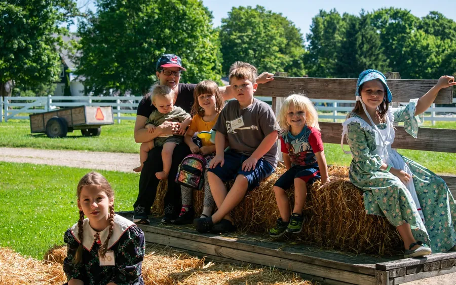 Families and children on a hay wagon during a Century Village gathering