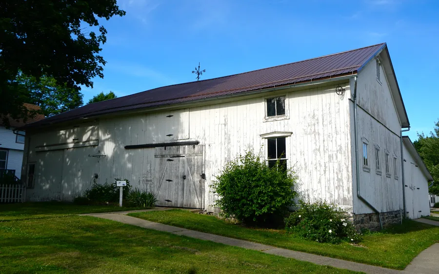 The restored white barn on the village green at Century Village Museum